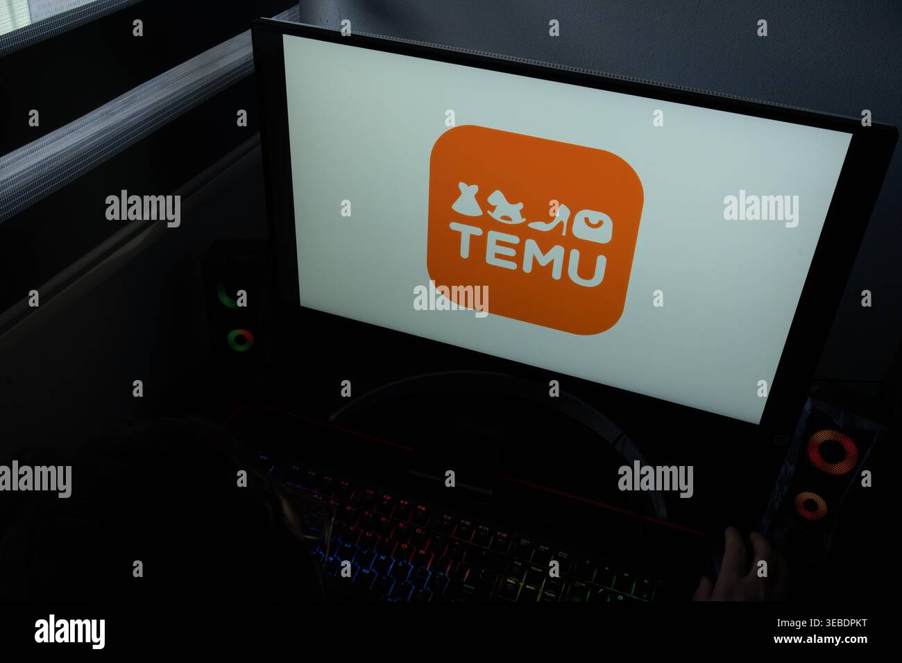 Das Temu E-Commerce Marketplace-Logo wird auf einem Computermonitor in einer dunklen Umgebung des Heimbüro angezeigt Stockfoto