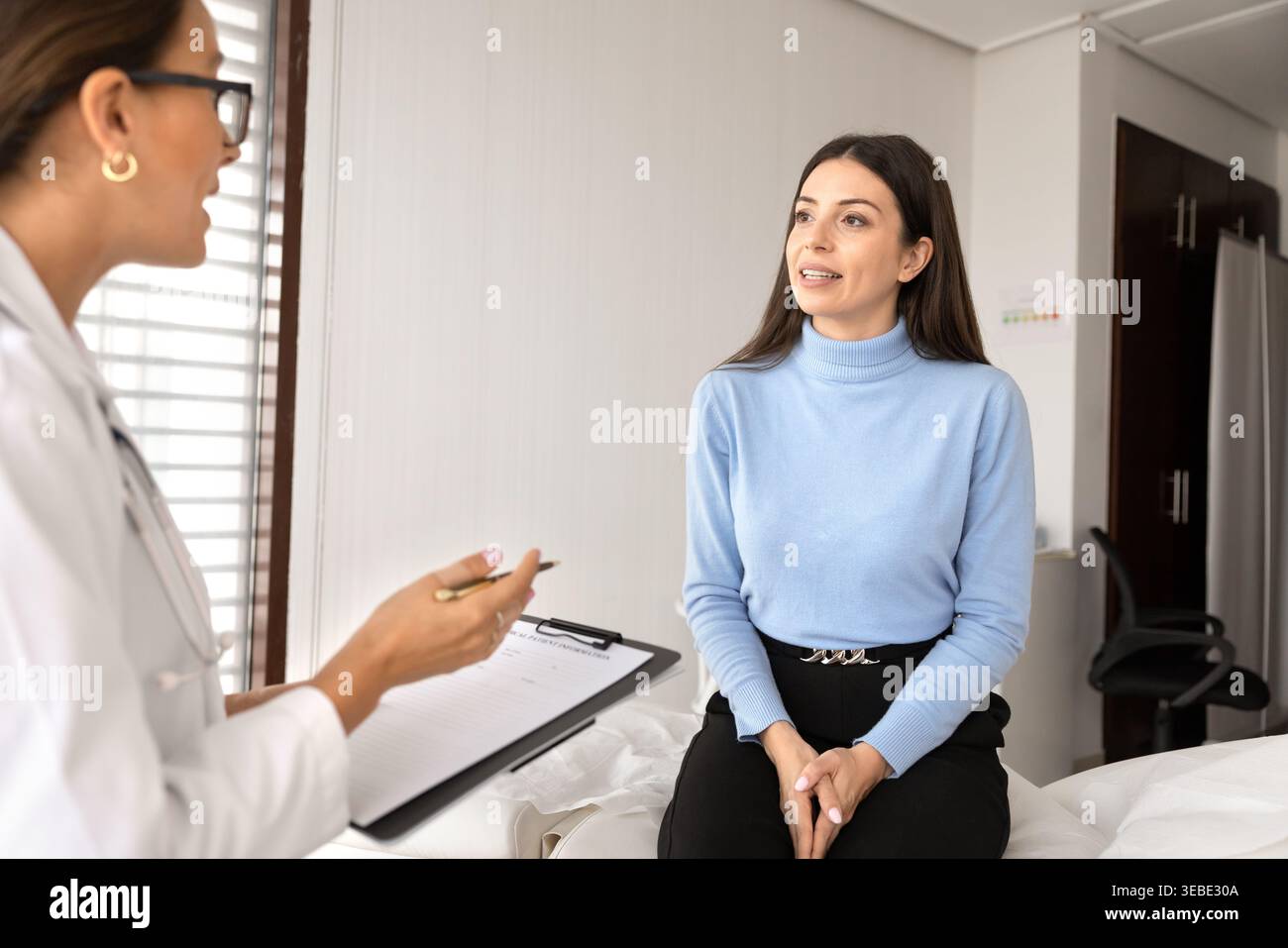 Arzt im Gespräch mit Patientinnen während ärztlicher Beratung in der Klinik Stockfoto