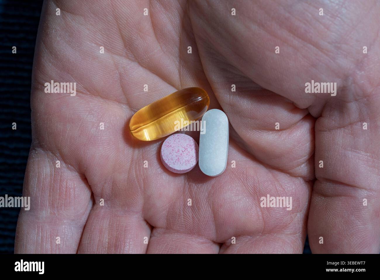 Drei verschiedene Pillen und Kapseln in einer menschlichen Hand. Hand mit Gelkapsel und Tabletten. Konzept der täglichen Medikamentenaufnahme Vitamine oder Stockfoto