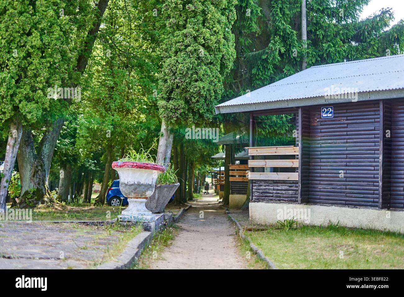 Ein malerischer Blick auf einen Ferienort oder Campingplatz mit dunklen Holzhütten mit horizontaler Blockhausverkleidung und Wellblechdächern. In der Stockfoto