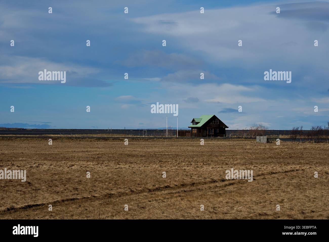 Einsame Holzhütte Mit Grünem Dach Im Weitläufigen Ländlichen Feld Unter Dramatischem Blauen Himmel Stockfoto