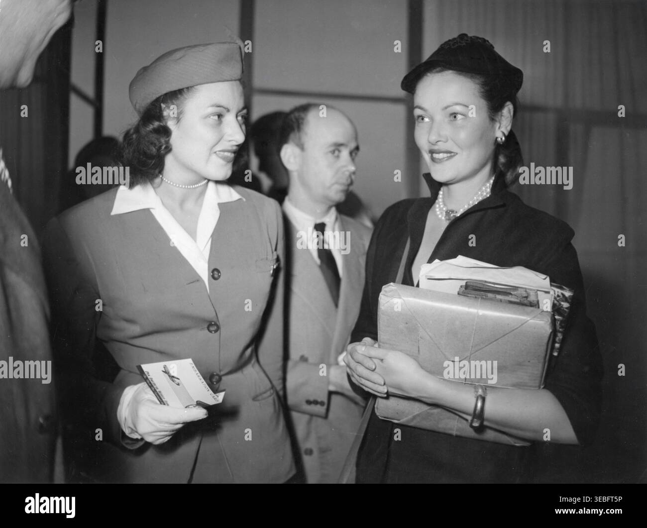 GENE TIERNEY, nachdem er im September 1951 vom Strato-Clipper der Pan American World Airways in Paris ausgestiegen war, fotografierte mit Stewardess Public für Pan American World Airways Stockfoto