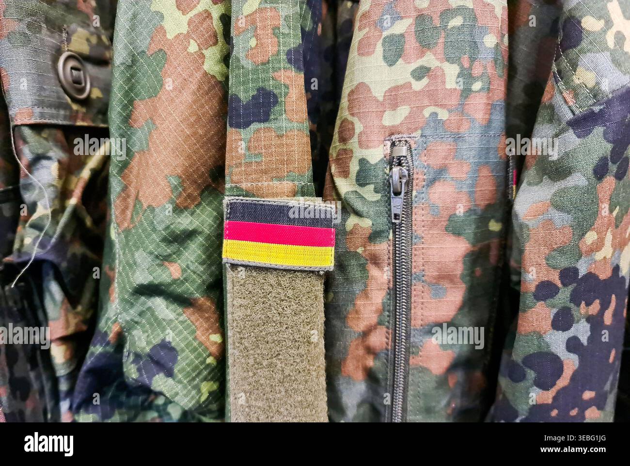 Militär-Camouflage-Uniformjacke mit deutschem Flaggenaufnäher zur Verteidigung und zum Dienst Stockfoto