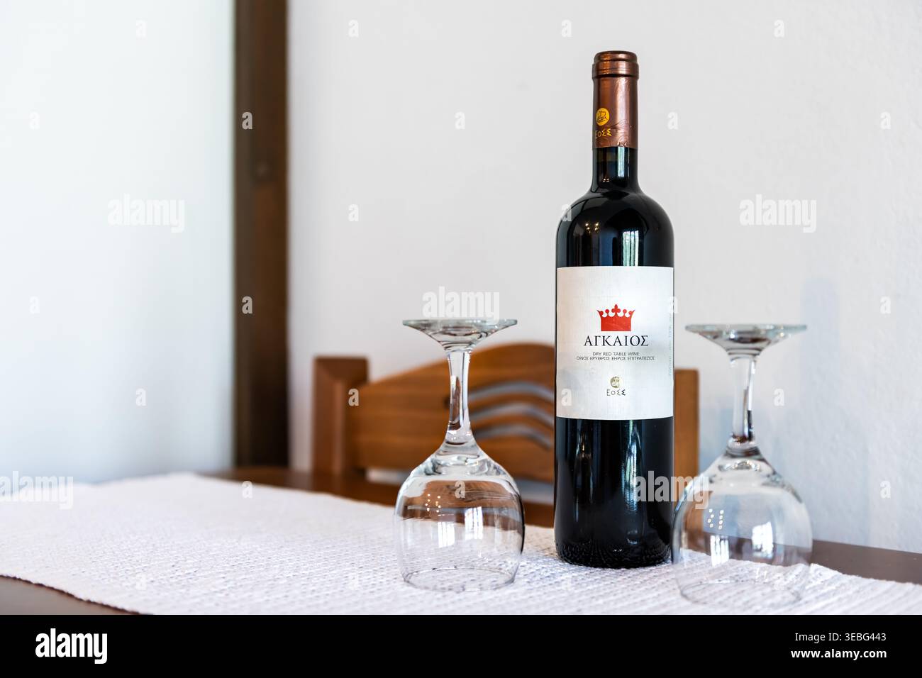 Insel Ikaria, Griechenland - 12. Juni 2023: Agaios eoss griechischer Rotwein mit Glasflasche und zwei Weingläsern zum Trinken in der Longevity Blue Zone Home Stockfoto