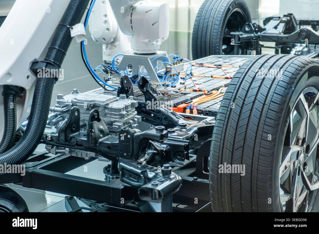 High-Tech-Display für die Automobilherstellung mit Roboterarmen, die Lithium-Ionen-EV-Batteriepack zusammenbauen, und einer Demonstration der Plattform für Elektrofahrzeuge Stockfoto