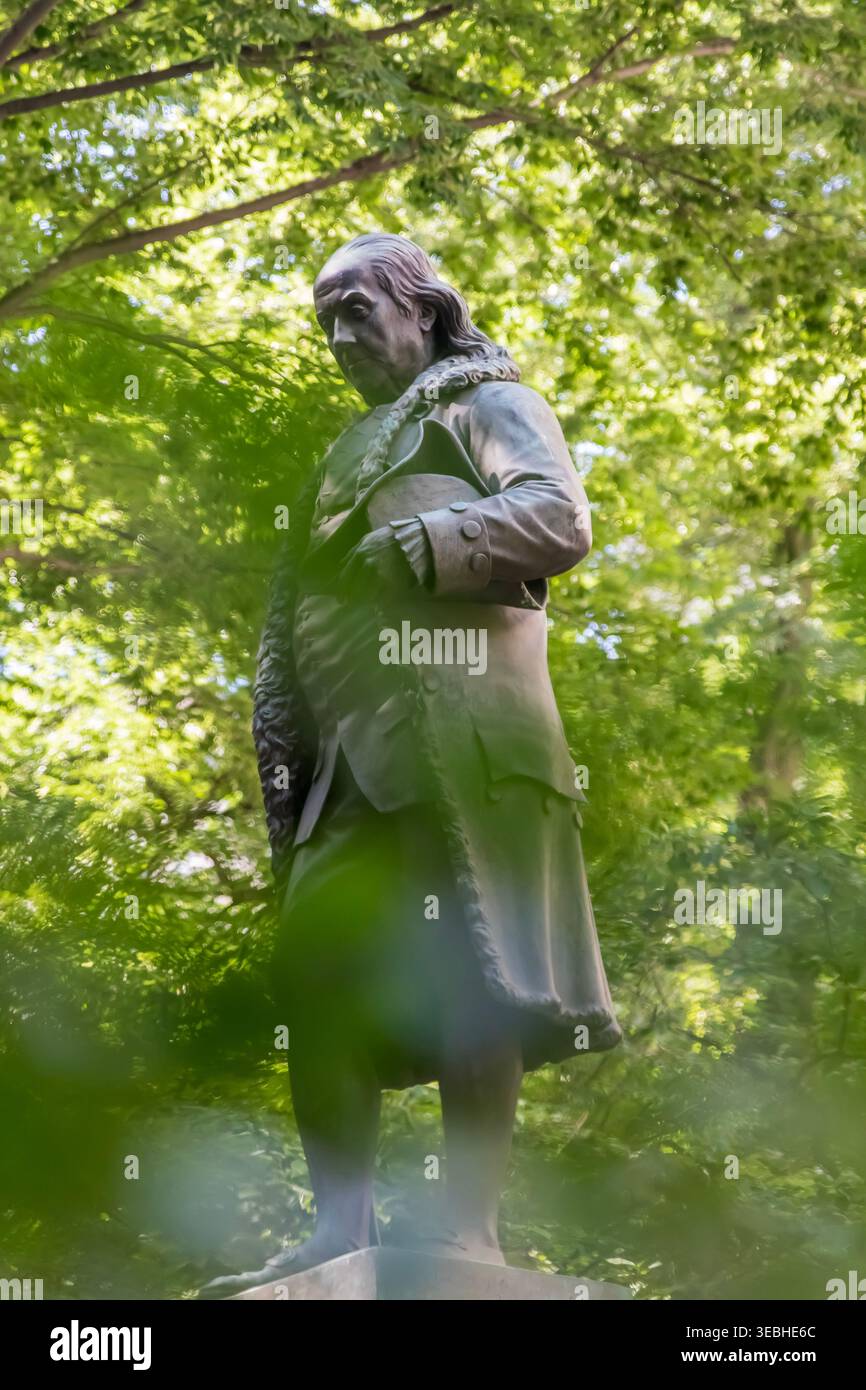 Eine Bronzestatue von Benjamin Franklin von Richard Saltonstall Greenough steht vor der Old City Hall in Boston, Massachusetts, auf einer detaillierten Basis mit Plaketten, die von Greenough und Thomas Ball entworfen wurden. Statue von Benjamin Franklin in Boston, Massachusetts Stockfoto
