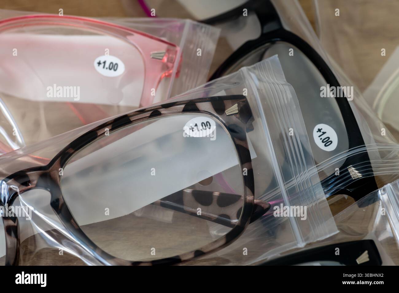 Eine Nahaufnahme von plus einer Sehkorrektur-Lesebrille in Kunststoffverpackungen. Stockfoto