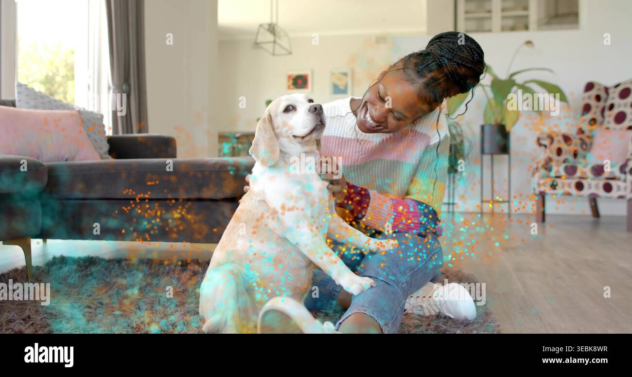 Sitzende Erwachsene Frau, die einen hellen Hund auf zotteligen Teppich streichelt, einen gestreiften Pullover und eine blaue Jeans trägt Stockfoto
