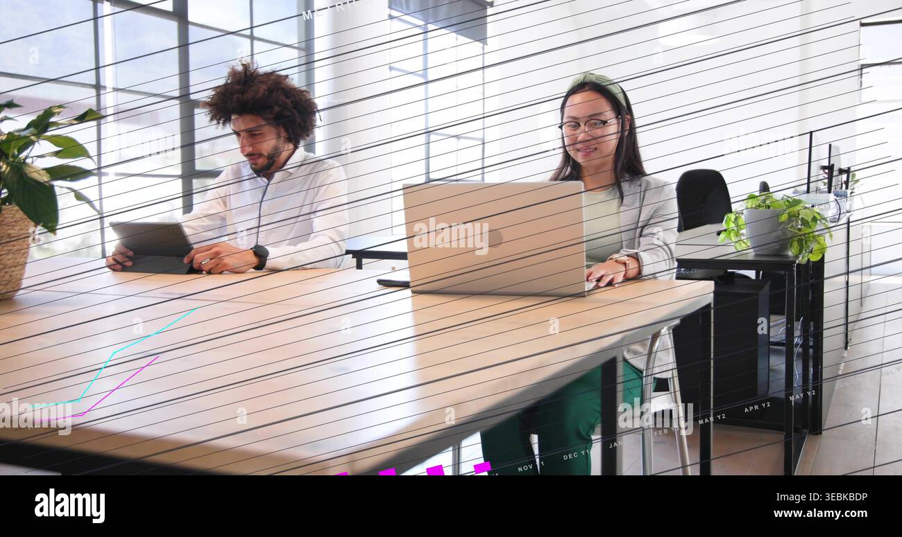 Arbeitender Mann aus dem Nahen Osten und Chinesin in Geschäftskleidung mit Tablet und Laptop am Tisch Stockfoto