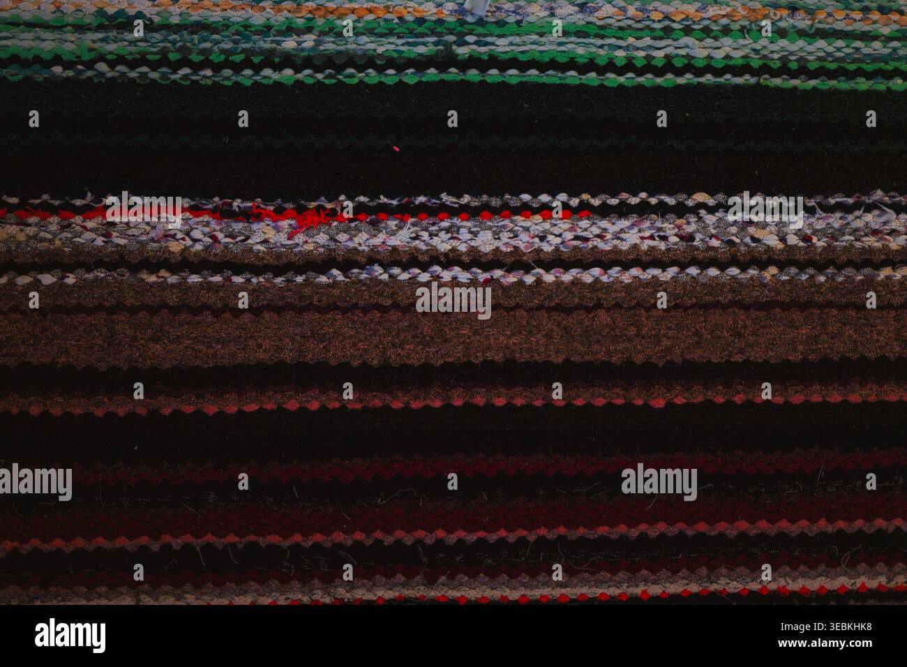 Bunte handgemachte Teppichtextur, gestreifter gewebter Stoffhintergrund mit blauen und grünen Fäden Stockfoto