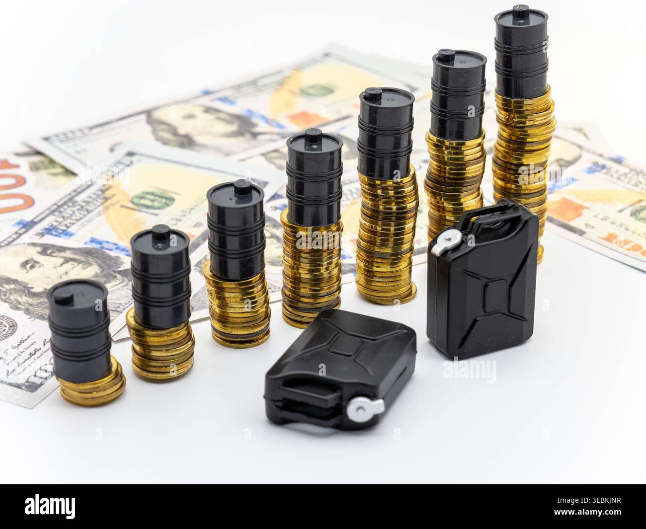Ölfass und gestapelte Münzen, symbolisch für finanzielle Schwankungen Stockfoto