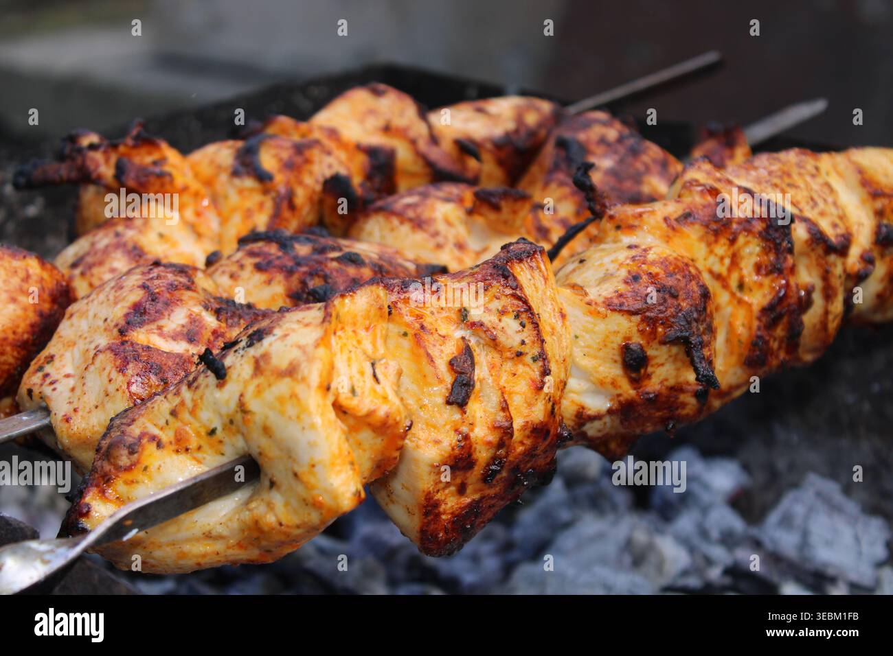 Saftige gegrillte Hähnchenspieße schaschig kochen auf Holzkohlegrill im Freien Stockfoto