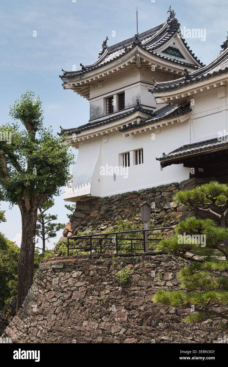 Detail eines traditionellen japanischen Burgturms (Yagura), der auf einer massiven, steilen Steinmauer am Wakayama Castle sitzt. Stockfoto