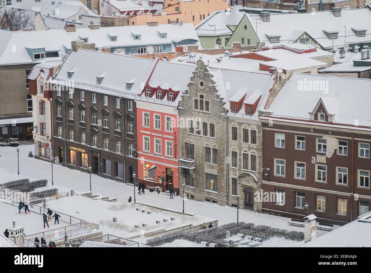 Tallinn, Estland - 03. Januar 2025: Blick auf schneebedeckte historische Fassaden, deren lebhafte Farbtöne sich in starkem Kontrast zur unberührten weißen Winterlandschaft bilden Stockfoto
