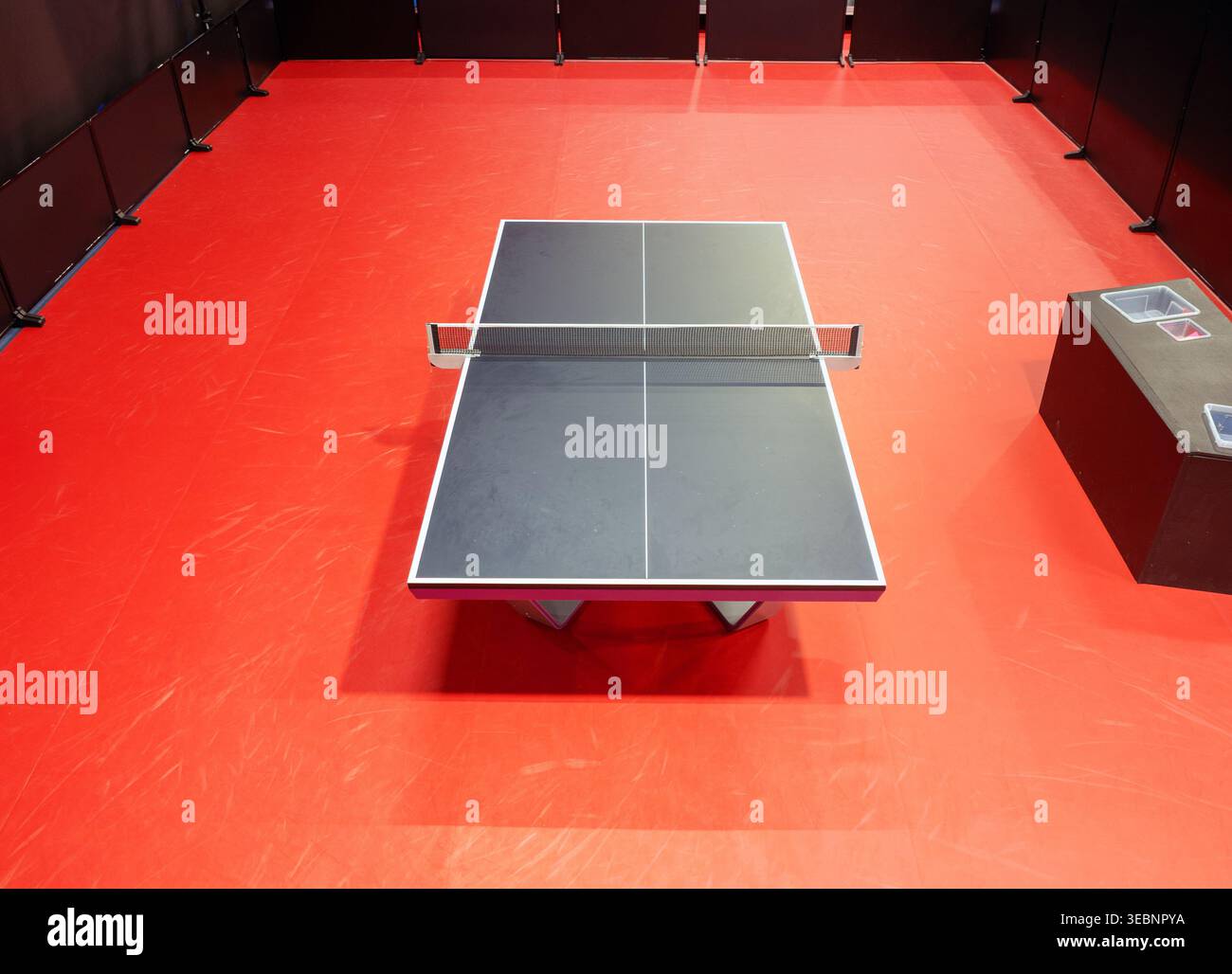 Tischtennis, schwarzer Tisch mit rotem Boden von oben. Hallensport. Tischtennisplatte. Gesundes Lifestyle-Konzept Stockfoto