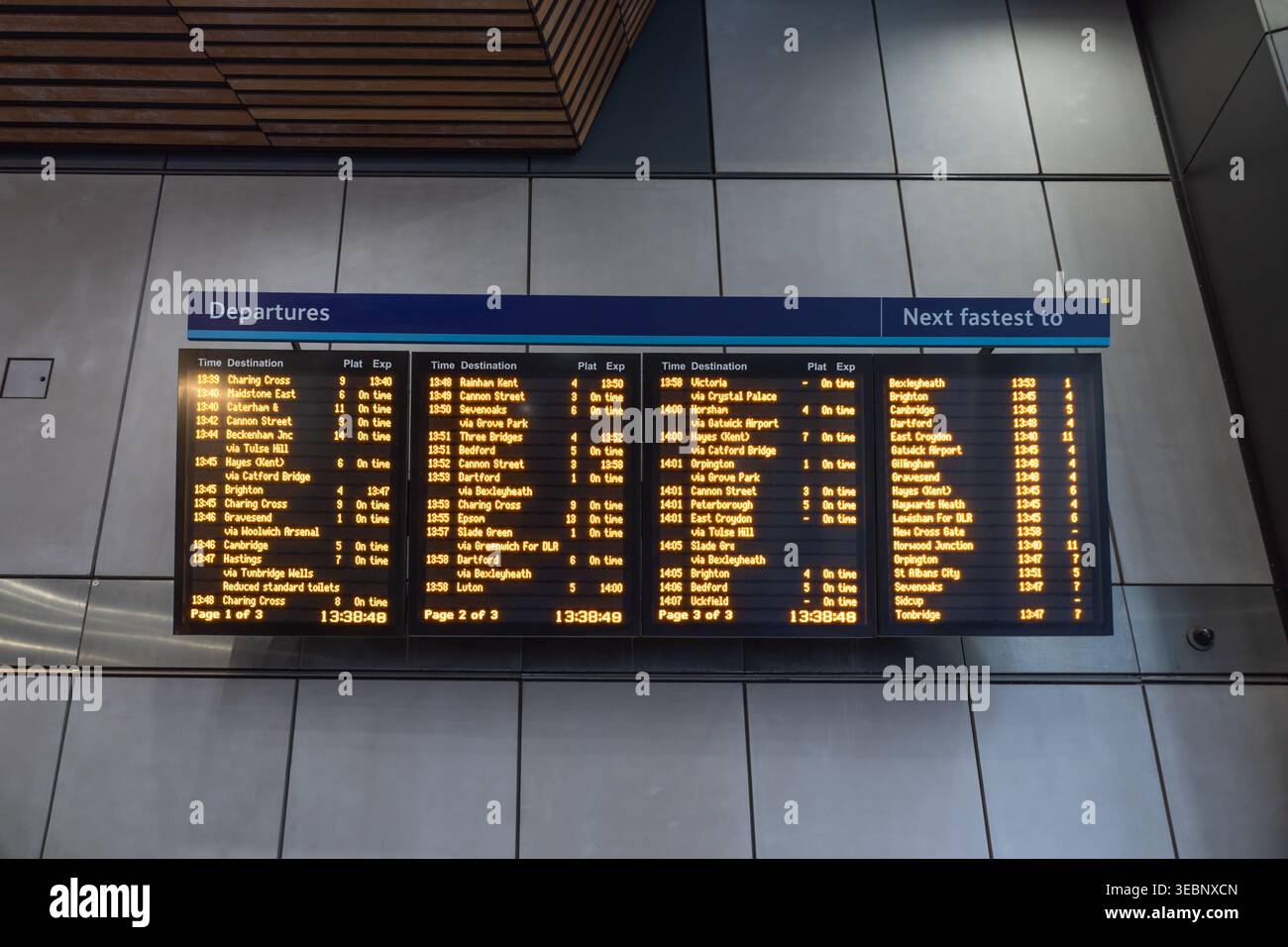 Abfahrtstafel des Bahnhofs mit orangefarbenem Text Stockfoto