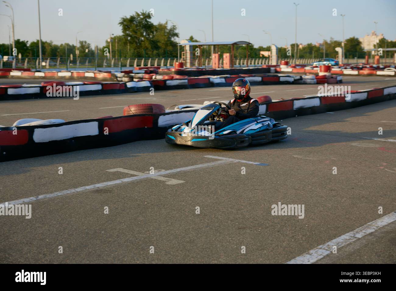 Ein aufregender Profi-Go-Kart-Rennfahrer fährt auf einer Outdoor-Trainingsstrecke Stockfoto