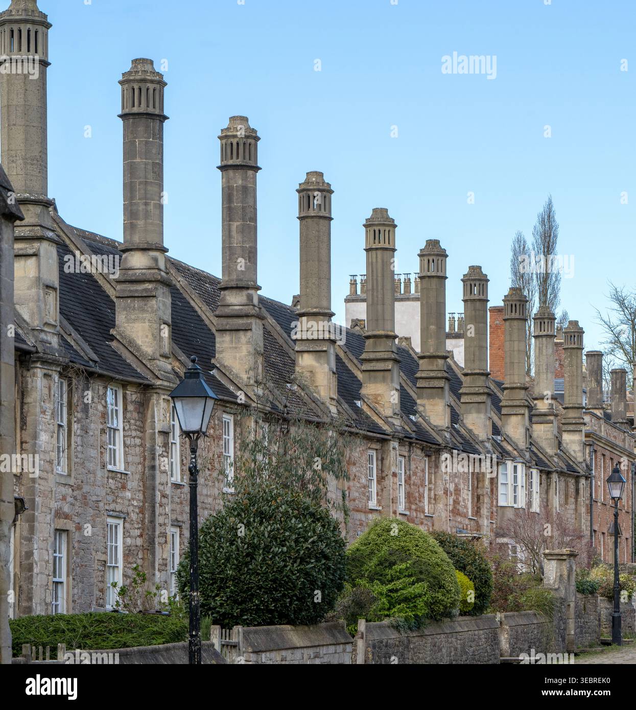 Reihe von mittelalterlichen Reihenhäusern aus dem 14. Jahrhundert mit hohen, markanten Schornsteinen auf Vicars' Close, Wells, Somerset, England, UK Stockfoto