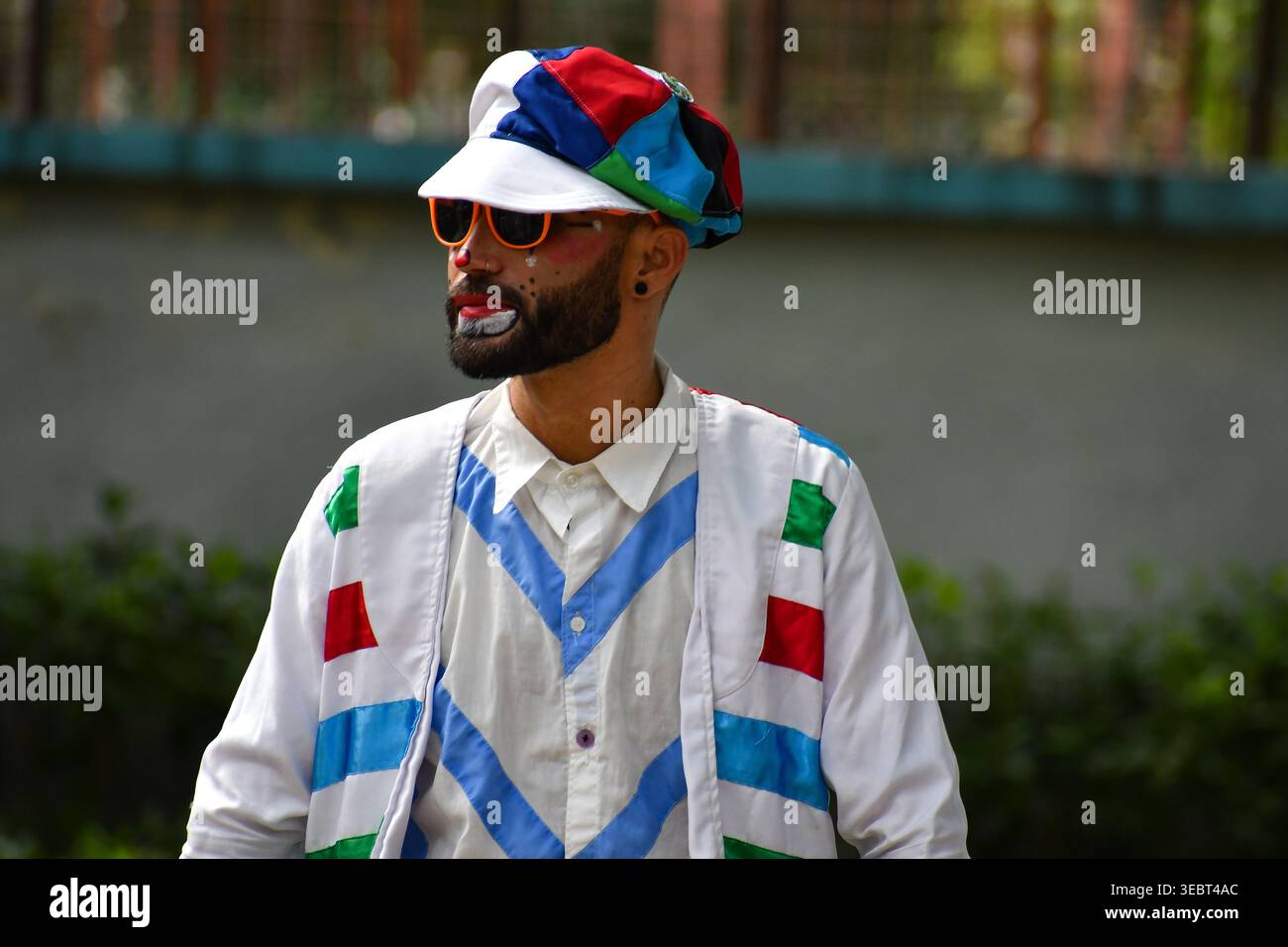 Ein lebendiges Porträt, das die Essenz städtischer Kreativität und persönlichen Ausdruck durch Make-up und Farbe einfängt – in diesem Clown. Stockfoto