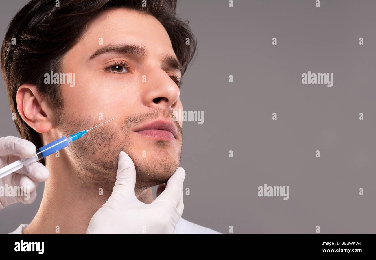 Kosmetikerin, Schönheit Injektion in Kiefer von männlichen Patienten Stockfoto