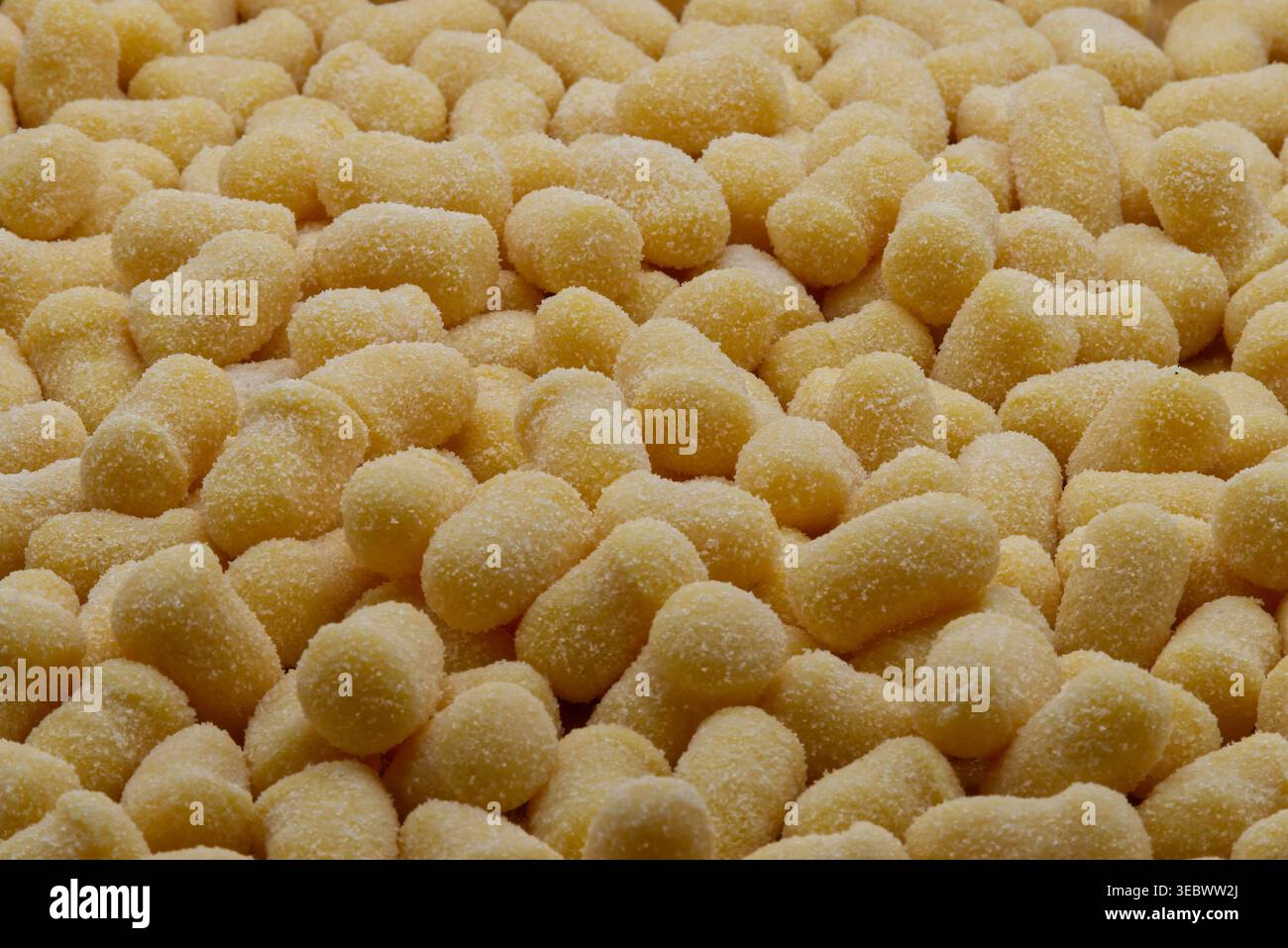 Eine Nahaufnahme der frischen, ungekochten, hausgemachten italienischen Kartoffelgnocchi, bedeckt mit weißem Mehl. Stockfoto