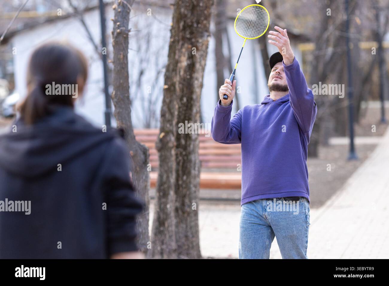 Mann schlägt einen Shuttlecock während Outdoor Badminton Stockfoto