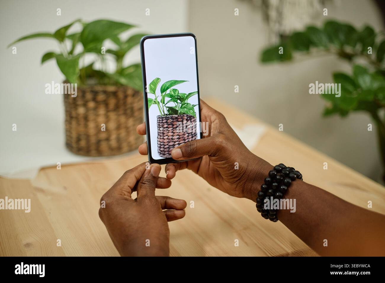 Schwarzer Erwachsener mit Smartphone für das Produktmarketing in Innenräumen Stockfoto