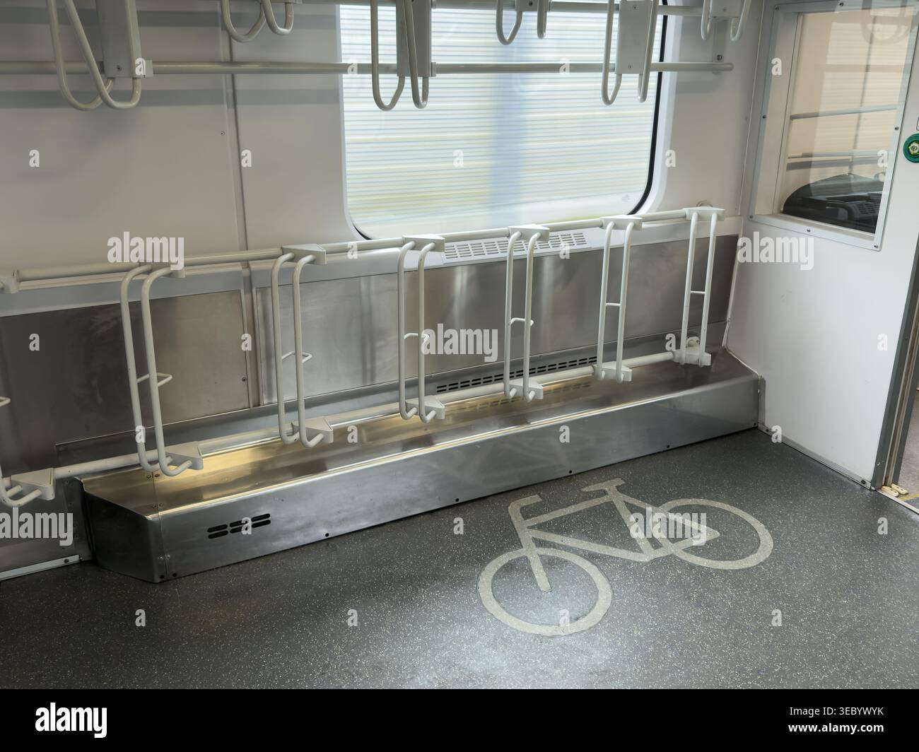 Innenansicht eines modernen Zugwagens mit integrierter Fahrradaufbewahrung mit weißen vertikalen Regalen und einem auffälligen weißen Fahrrad Stockfoto