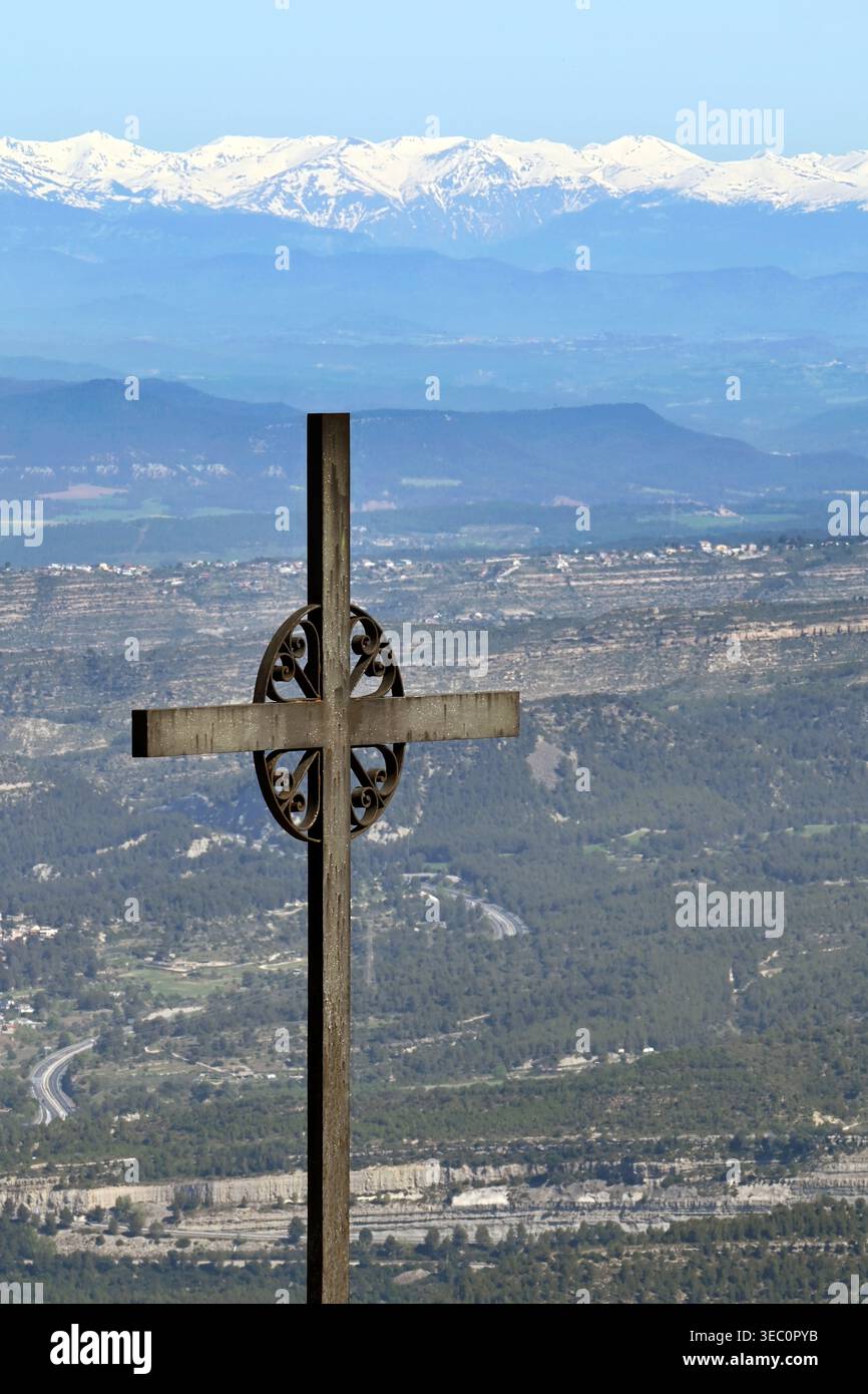 Eisernes Kreuz von Saint Michael (Creu de Sant Miquel) mit Blick auf die schneebedeckten Pyrenäen und die Tallandschaft unter blauem Himmel in Montserrat, Spanien Stockfoto