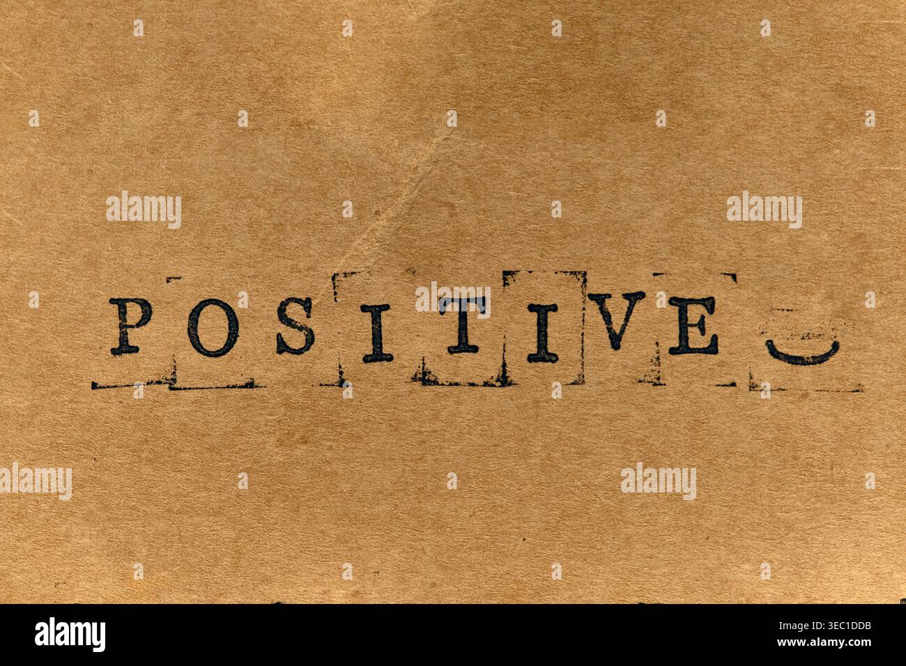 Wort POSITIV mit Smiley-Symbol auf strukturiertem Pergamentpapier Stockfoto