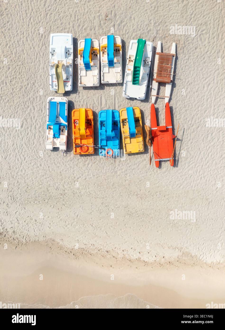 Blick aus der Vogelperspektive auf farbenfrohe Katamarane am leeren Sandstrand Stockfoto