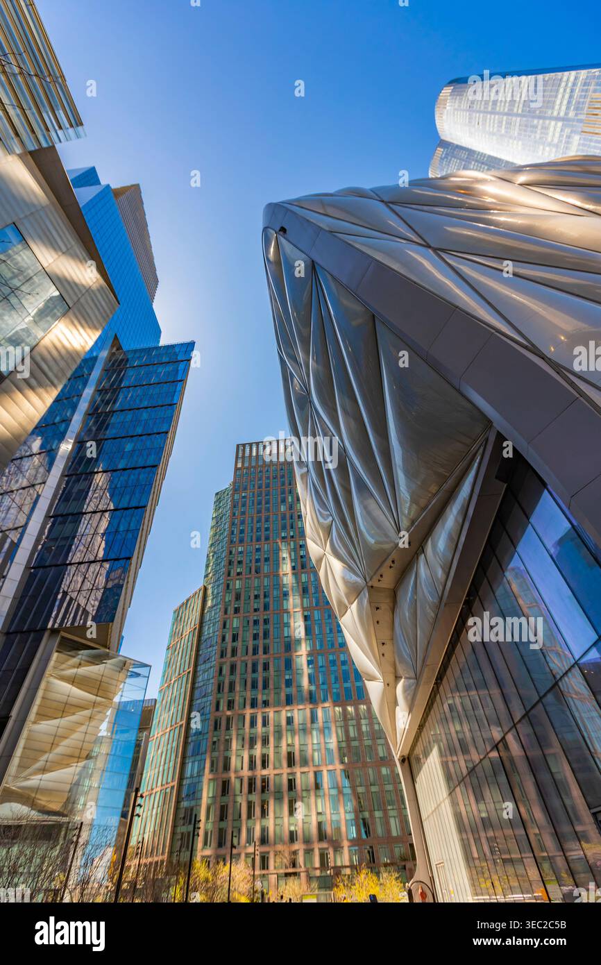 Besucher bewundern die einzigartige Architektur des Schuppen im Sonnenlicht. Die umliegenden Wolkenkratzer spiegeln die lebhafte Atmosphäre von Hudson Yards wider. Stockfoto