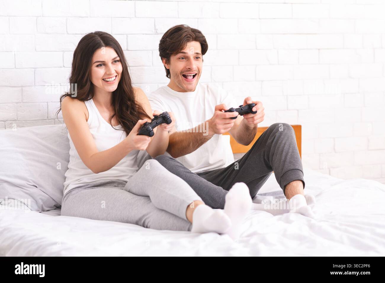 Paare, die gemeinsam in einem gemütlichen Schlafzimmer spielen Stockfoto