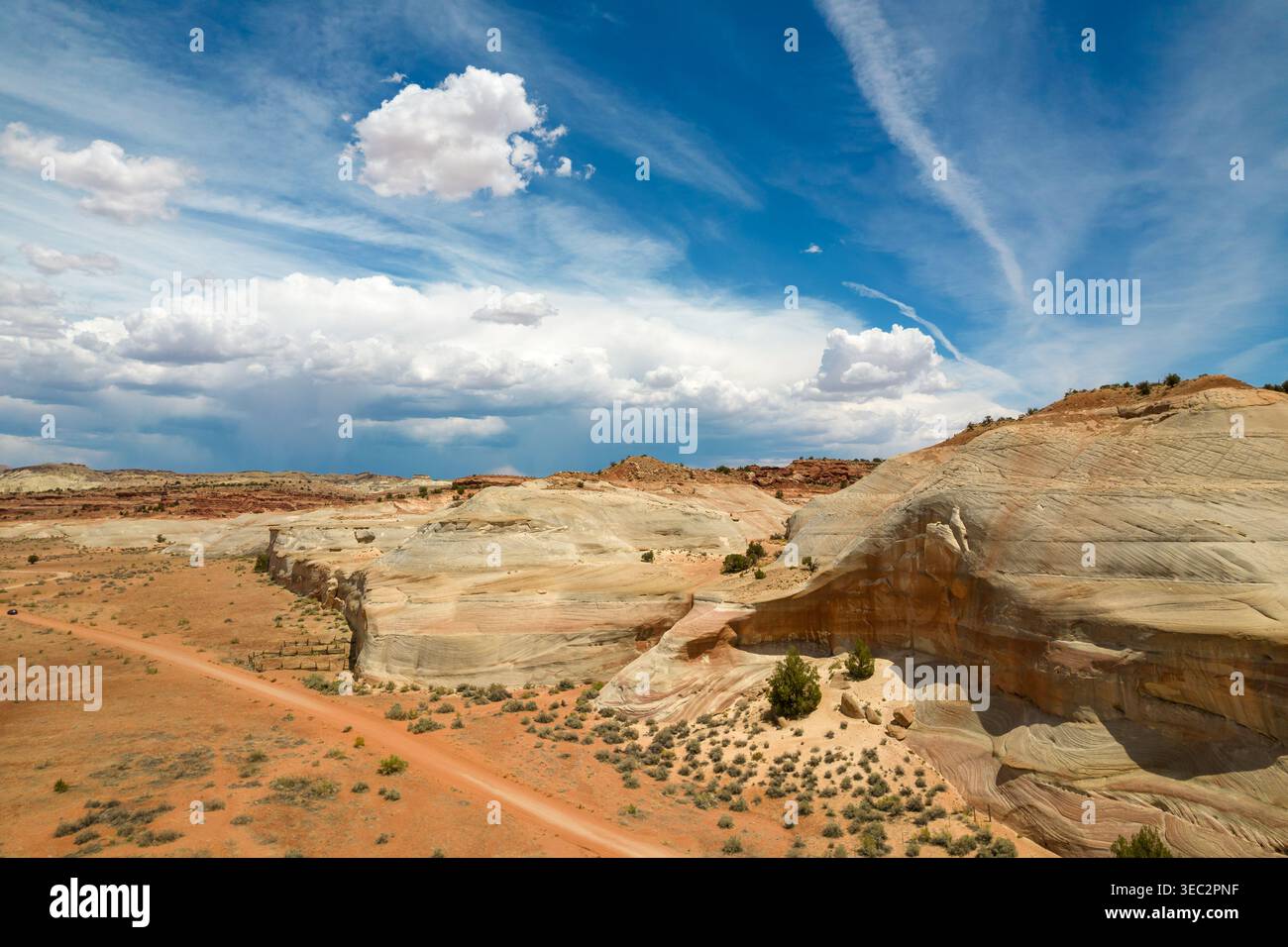 Aus der Vogelperspektive des Weißen Hauses Trailhead in Utah mit einer gewundenen Feldstraße und farbenfrohen Sandsteinformationen unter einem dramatischen Himmel. Stockfoto