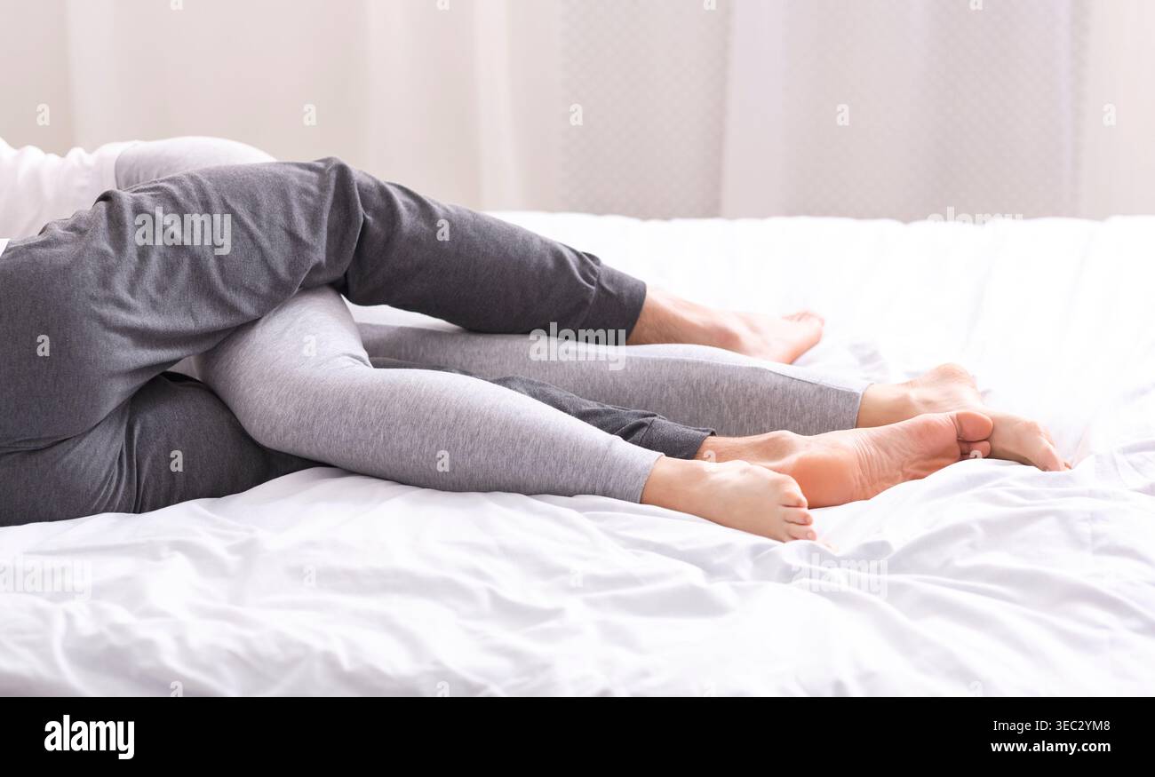 Gemütliche Momente für zwei Personen, die sich auf einem Bett in komfortabler Kleidung entspannen Stockfoto