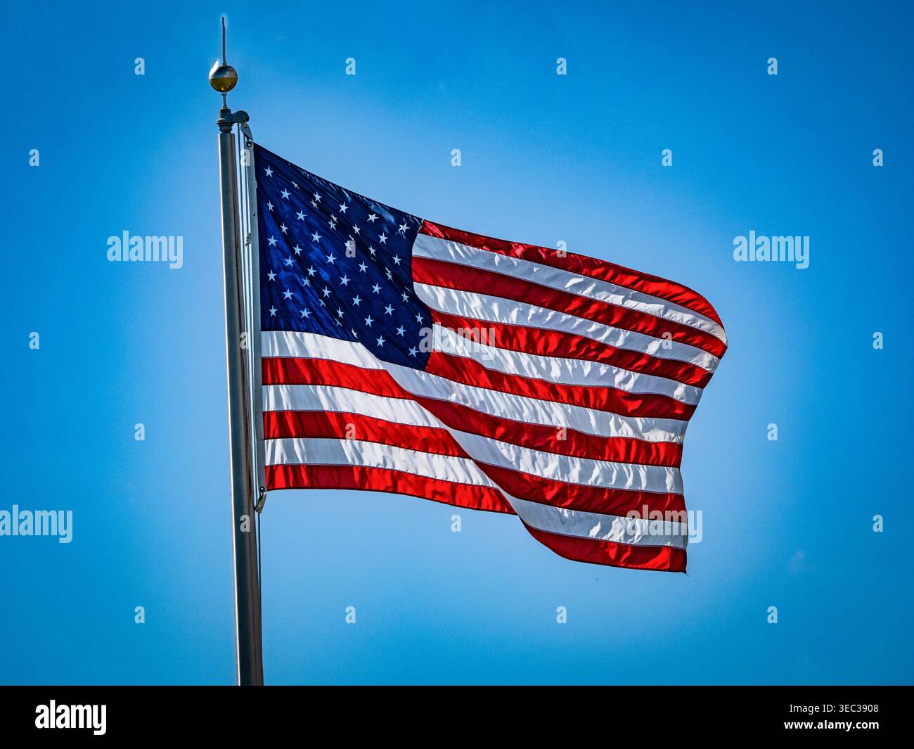 Amerikanische Flagge fliegt vor einem blauen Himmel, eingerahmt von einem weißen Leuchten Stockfoto