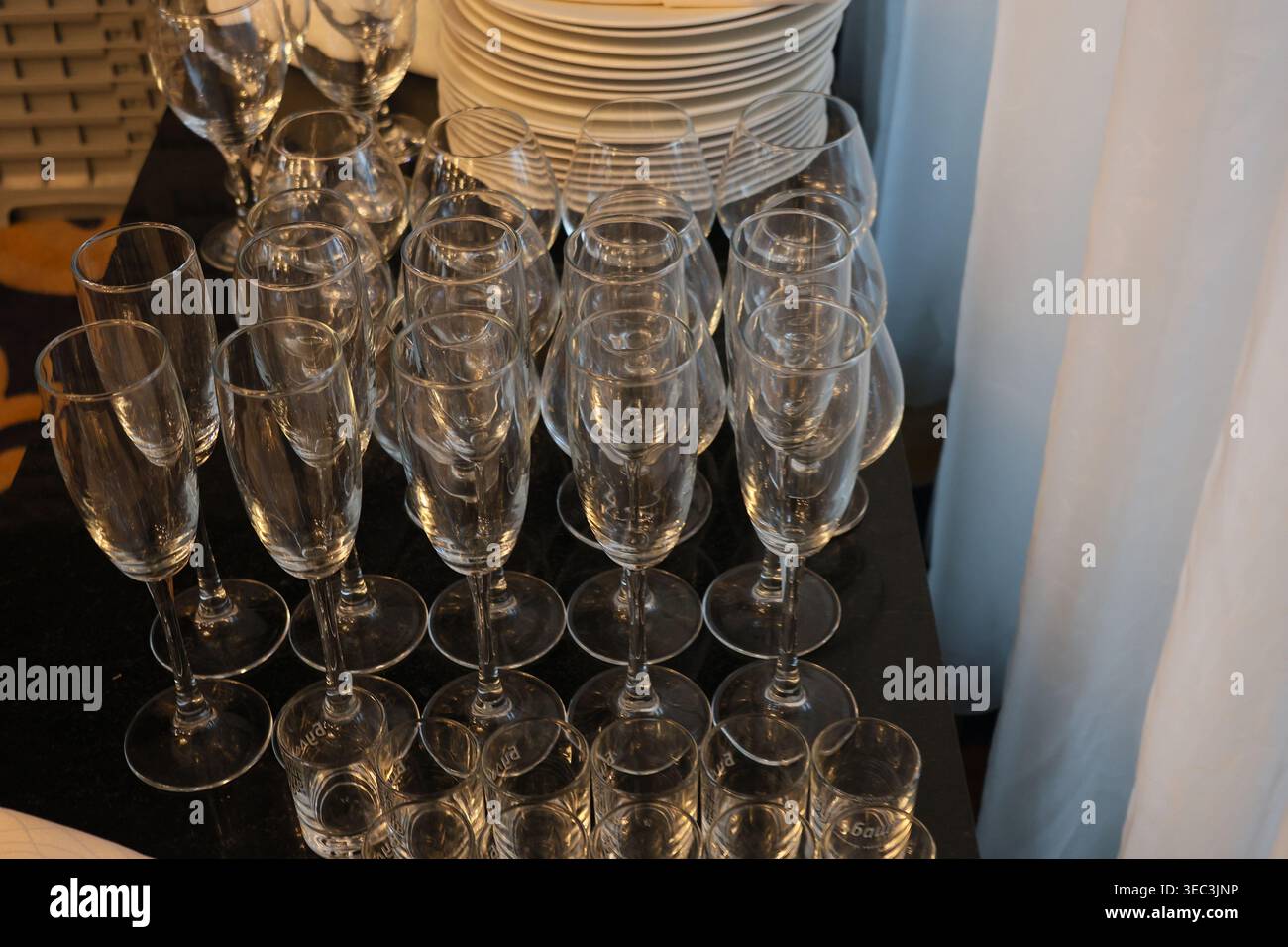 Die Gläser sind alle leer und die Teller sind ordentlich angeordnet. Die Szene ist elegant und raffiniert Stockfoto