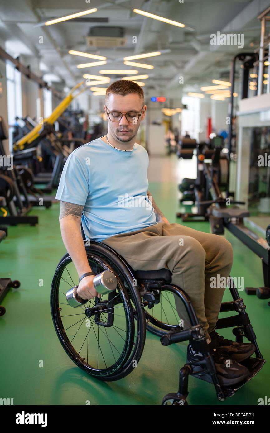 Behinderter männlicher Athlet, der mit Hantel trainiert, Gewichtheben für Armstärke macht. Stockfoto