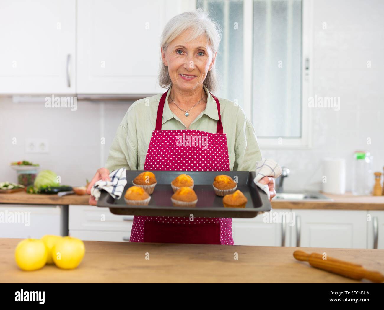 Reife Frau, die zu Hause VanilleMuffins backt Stockfoto