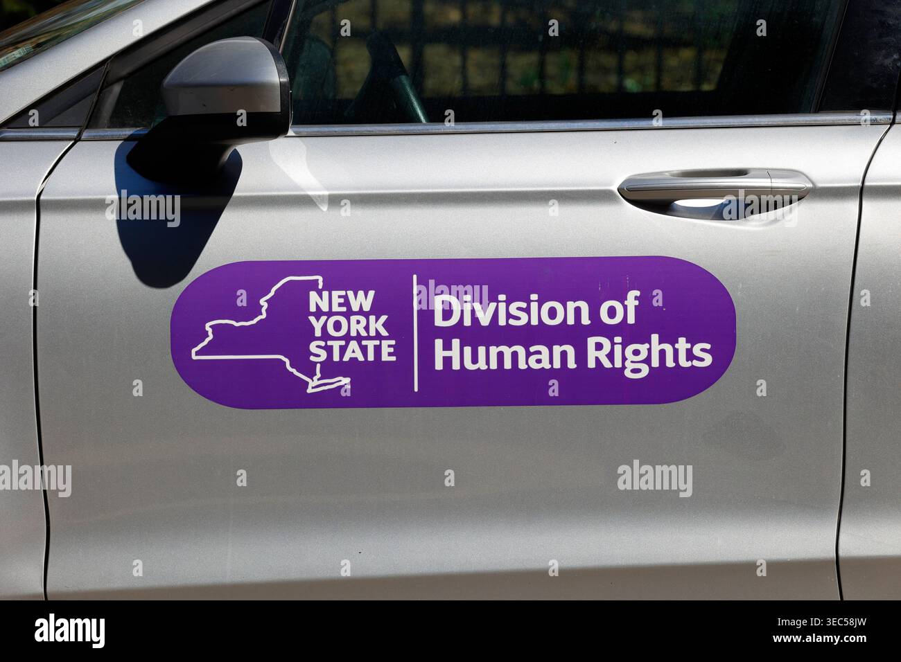 Ein Aufkleber mit der Bezeichnung "New York State Division of Human Rights" an einer Autotür. Stockfoto