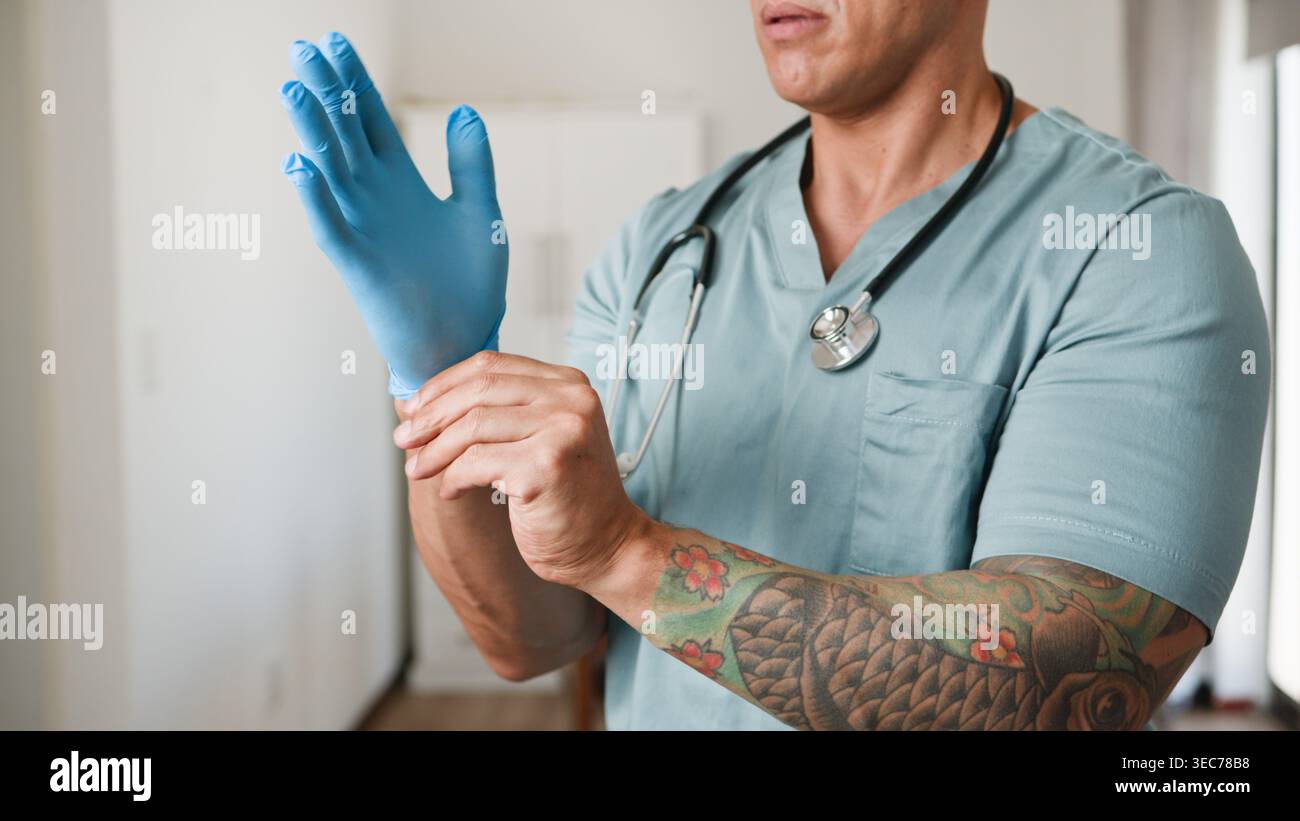 Tätowierter Arzt, Der Blaue Medizinische Handschuhe Mit Stethoskop In Der Klinik Anzieht Stockfoto