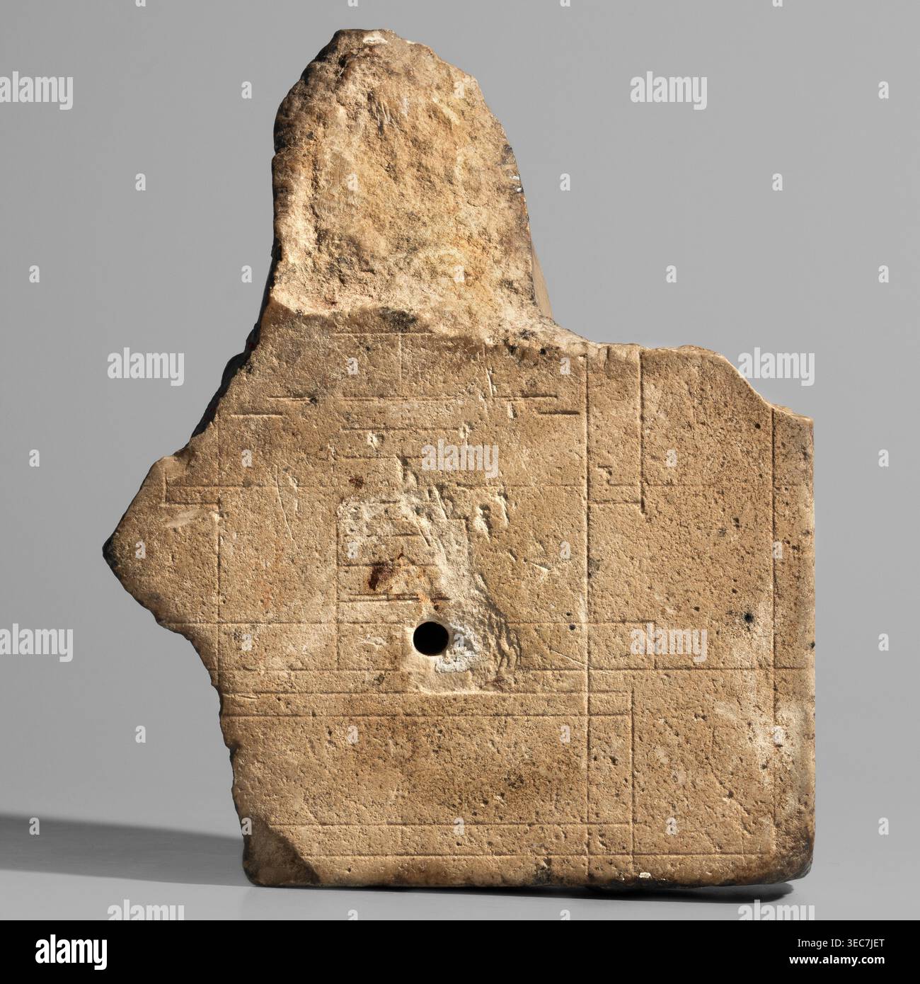 Skulpturales Modell — Kopf von Nectanebo I oder II. Skulpturenmodell eines Herrscherkopfes im Vollrelief, befestigt auf einer flachen Platte Hintergrund fragmentarisch auf der rechten Seite erhalten. Das Lineal trägt eine Neme, die die Hälfte der Stirn bedeckt, die vorne mit einem Uräus verziert ist, dessen Körper in einem horizontalen Zickzack gerollt ist, ähnlich einer Acht mit geradem Schwanz. Die Nemes tragen verdrehte Widderhörner. Das Gesicht ist oval und prall mit abgerundetem Kinn und Wangen; kleiner Mund mit gleich breiten Ober- und Unterlippen und leicht nach oben gerichteten Ecken; lange Nase; kleine, eng anliegende, leicht schräge Augen mit Ober- und Unterlippe Stockfoto