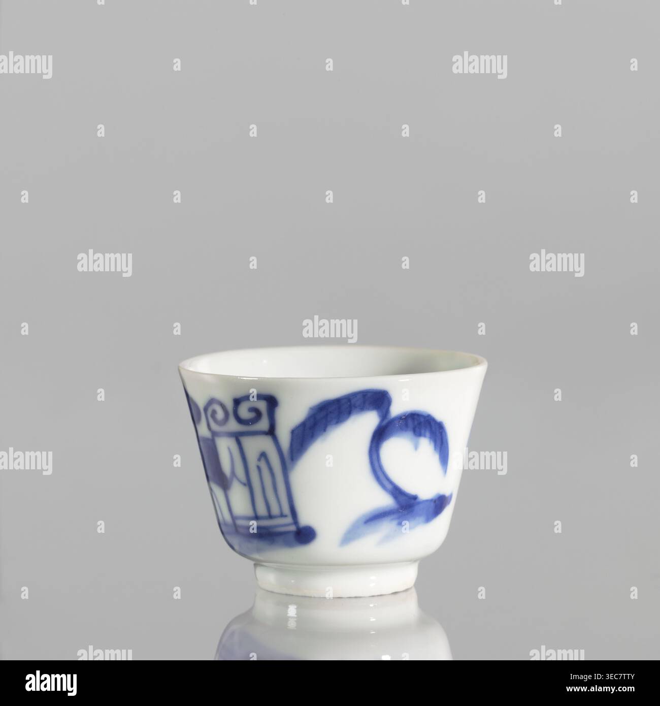 Schüssel, Keramik, blaues und weißes Porzellan, Qing-Stil, chinesische Kunst, chinesische Kultur, Landschaften mit Architektur, Landschaften mit Personal, Landschaftsmotive, Qing 1644–1911, Porzellankeramik, grau-weiß. Schüssel mit ausgestellten Kanten auf einem niedrigen Ringfuß, 19. Jahrhundert, China; Gefäß; Höhe 4,4 cm, Durchmesser 5,8 cm., Eine kleine weiße Porzellanschale mit blau bemalten Mustern um die Außenseite, die einige geschwungene Pinselstriche und dekorative Motive zeigt, auf einem einfachen hellgrauen Hintergrund und auf einer reflektierenden Oberfläche, die den Boden des Bechers spiegelt; sichtbare Farben sind weiß, Blau und Licht Stockfoto