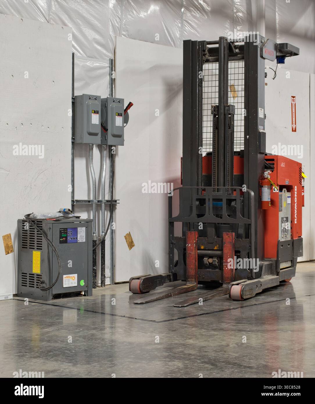 Houston, Texas USA 27. April 2026: Schubmaststapler und Batterieladestation im Lager abgestellt. Stockfoto