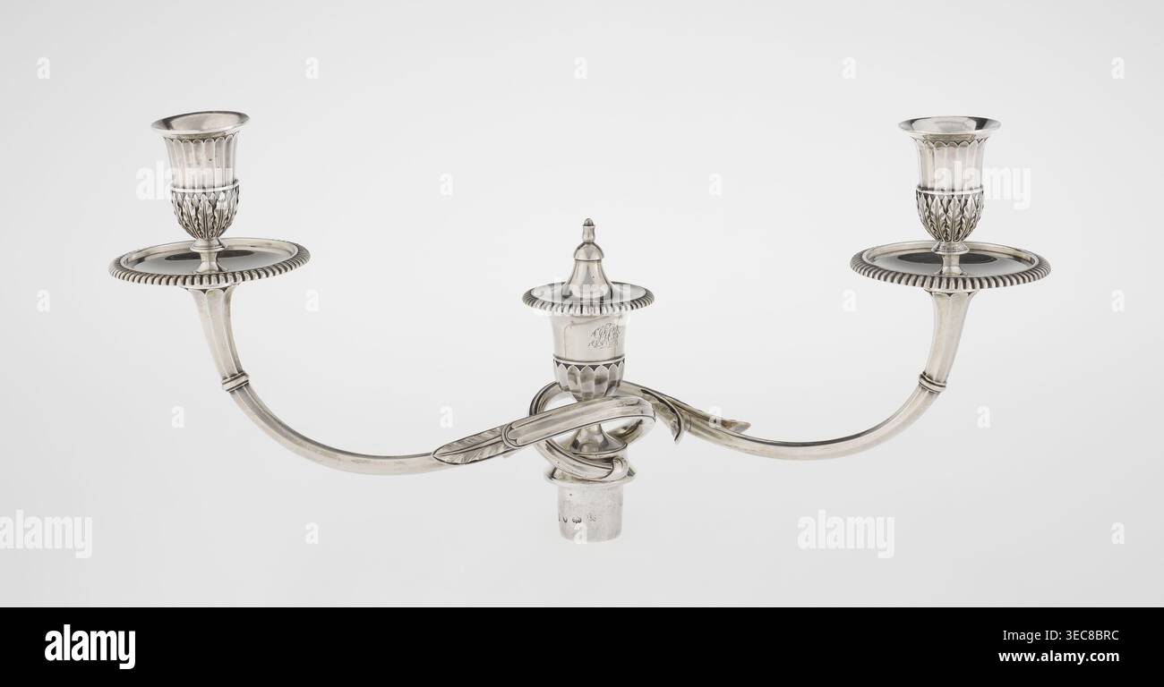 Klassizistische zweiarmige Kerzenleuchter, Schofield, John fl. 1776–1796 Goldschmied, Klassizismus, Godron Ornamente, Monogramme, Facettierung, Blätter Ornament, georgianisch/George III Stil. Klassizistischer zweiarmiger Kandelaber auf quadratischem Boden, umgeben von Godron-Ornamenten, geht in einen kreisförmigen Fuß über, der mit einer umliegenden Rosette verziert ist; facettierter Stiel, der oben mit einer gerändelten Blumenranke umgeben ist und in einem vasenförmigen Sockel endet, der mit Akanthusblättern und Facetten verziert ist, umrandet mit Godronen, mit zwei facettierten, drehbaren Armen, die mit Tellern enden Tropflossen sind und kerzenförmigen Kerzenständern, getrennt durch ein Stockfoto