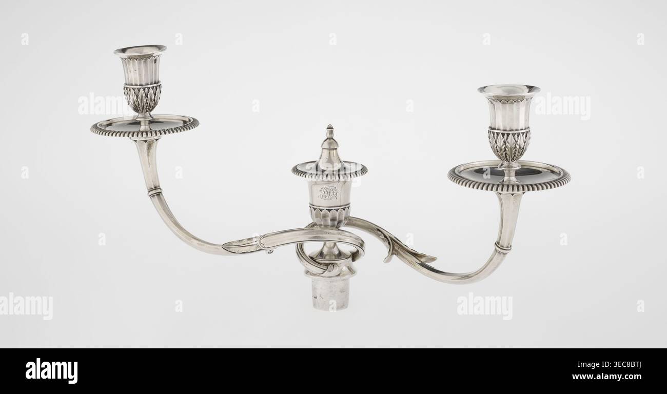 Klassizistische zweiarmige Kerzenleuchter, Schofield, John fl. 1776–1796 Goldschmied, Klassizismus, Godron Ornamente, Monogramme, Facettierung, klassizistischer zweiarmiger Kandelaber auf quadratischem Boden, umgeben von Godron-Ornamenten, geht in einen kreisförmigen Fuß über, der mit einer umliegenden Rosette verziert ist; facettierter Stiel, der oben mit einer gerändelten Blumenranke umgeben ist, die in einem vasenförmigen Sockel endet, der mit Akanthusblättern und Facetten verziert ist, umrandet ist, in der Form von zwei facettierten, rotierenden Armen, die mit einer kerzenförmigen Kerzenform enden Kerzenförmigen Kerzenvenen Kerzenvenen Kerzenvase Stockfoto