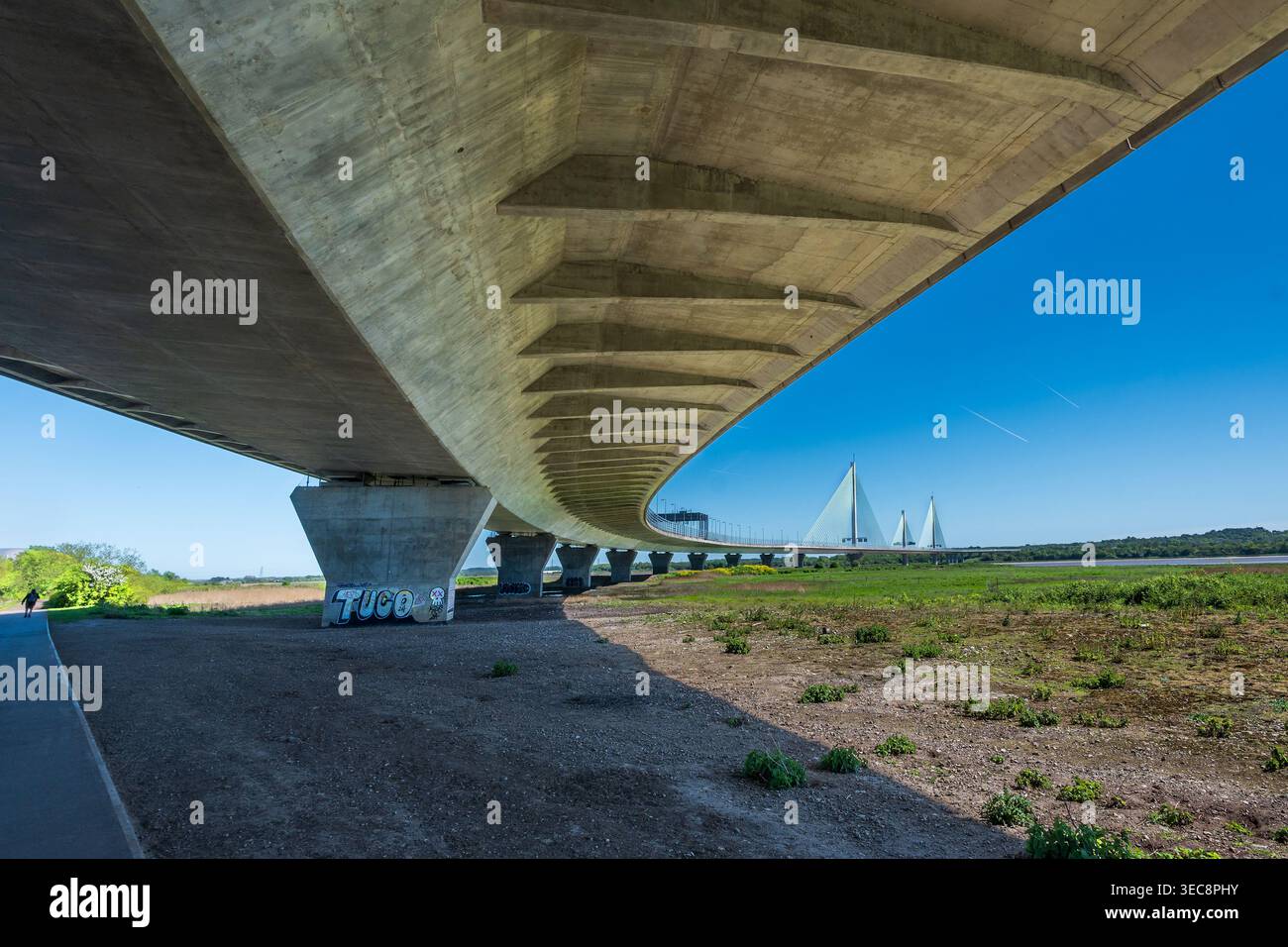 Unter der beeindruckenden Brücke über den Mersey River entfaltet sich die lebhafte Landschaft. Klarer Himmel und warmes Sonnenlicht unterstreichen die Schönheit dieses ICs Stockfoto