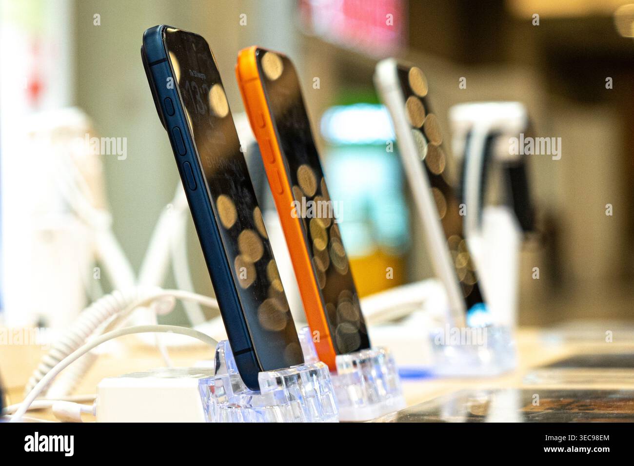 Moderne Smartphones mit einzigartigem Design, elegant auf Ständen im Einzelhandel mit sanfter Hintergrundbeleuchtung Stockfoto