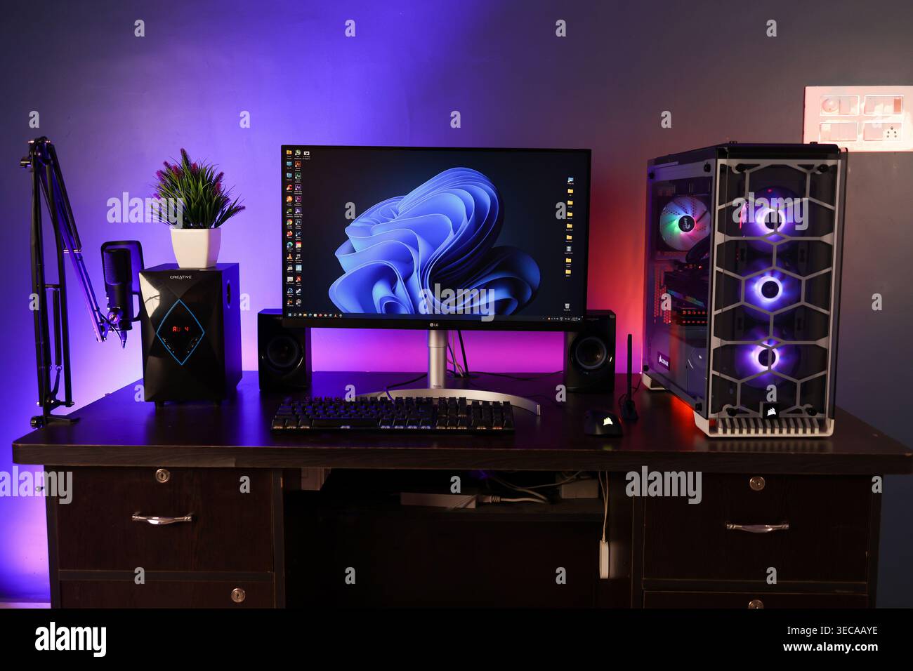 Ein Windows 11 Desktop-PC-Setup in einem dunklen Hintergrund, dies ist ein High-End-Gaming- oder Editing-Computer mit RGB-Lichtern. Ein perfektes Studio- oder Büromöbel. Stockfoto