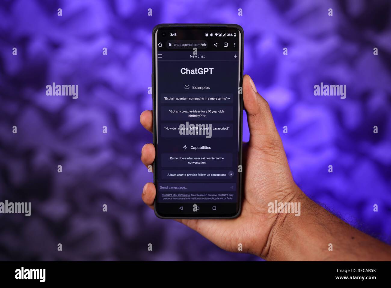 Chatgpt-Schnittstelle auf Mobile hält von einer Hand mit abstraktem blauem Hintergrund, dies ist eine KI-App für künstliche Intelligenz, um Fragen zu stellen. Bildschirm für den Dunkelmodus. Stockfoto